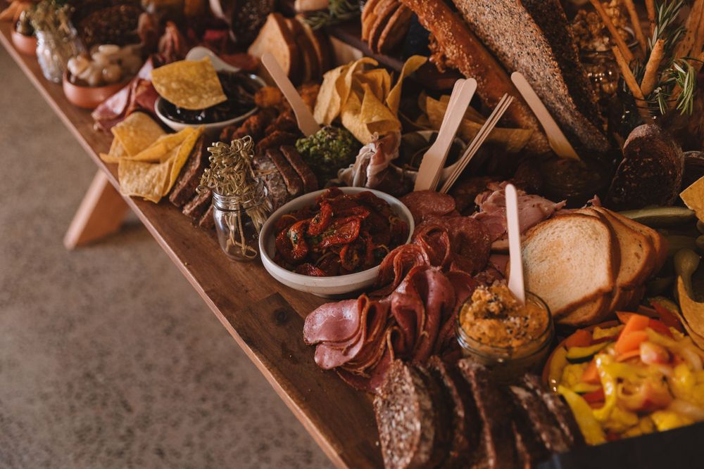 Close-up of gourmet charcuterie spread featuring meats, breads, and colorful accompaniments.