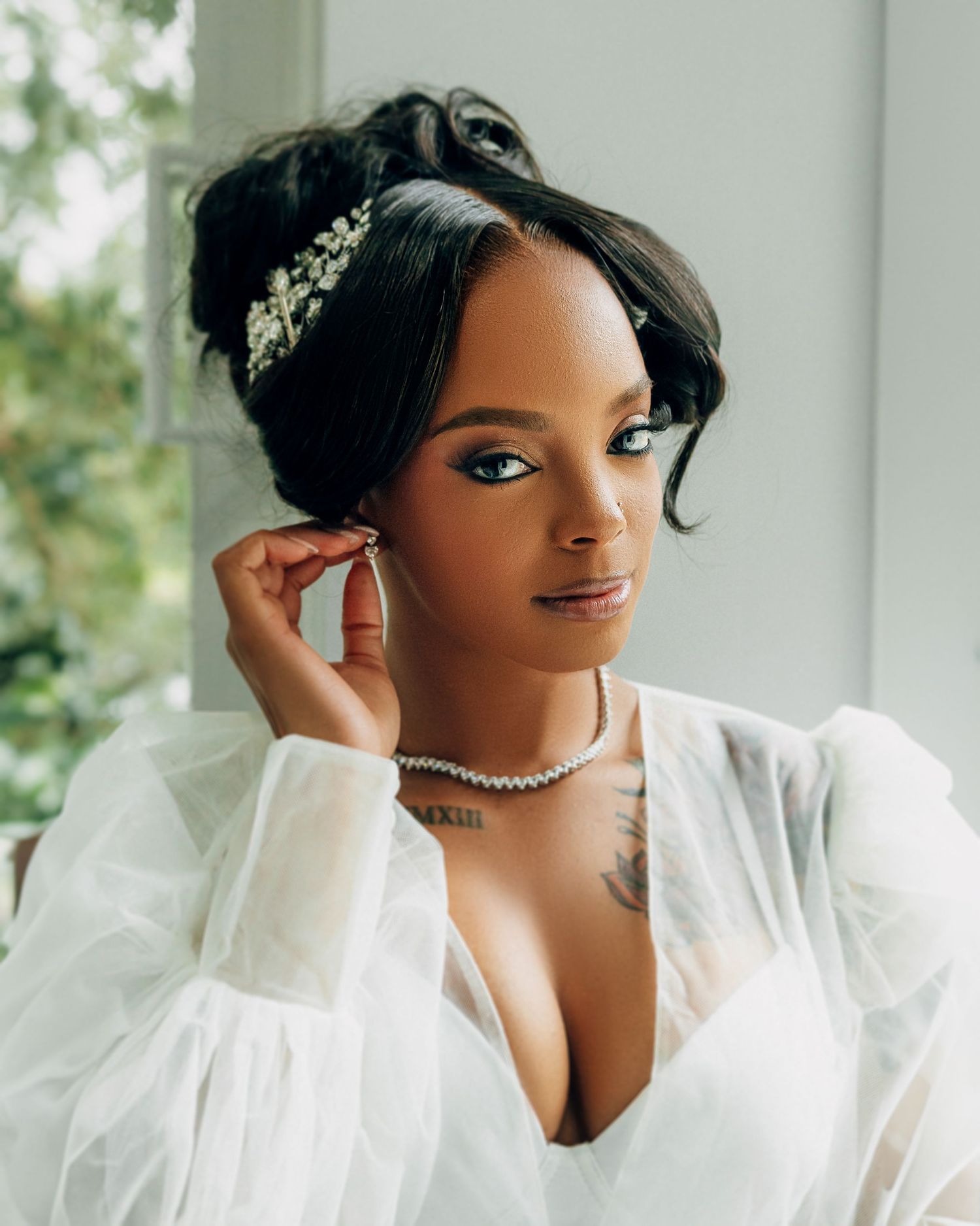Bridal portrait showing elegant pearl jewelry and crystal hair accessory.