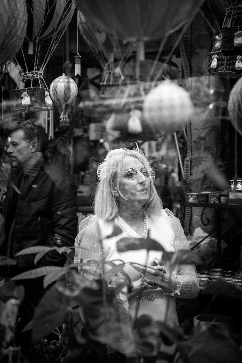 Black and white image of a vintage shop window display with hanging lamps and glass reflections.