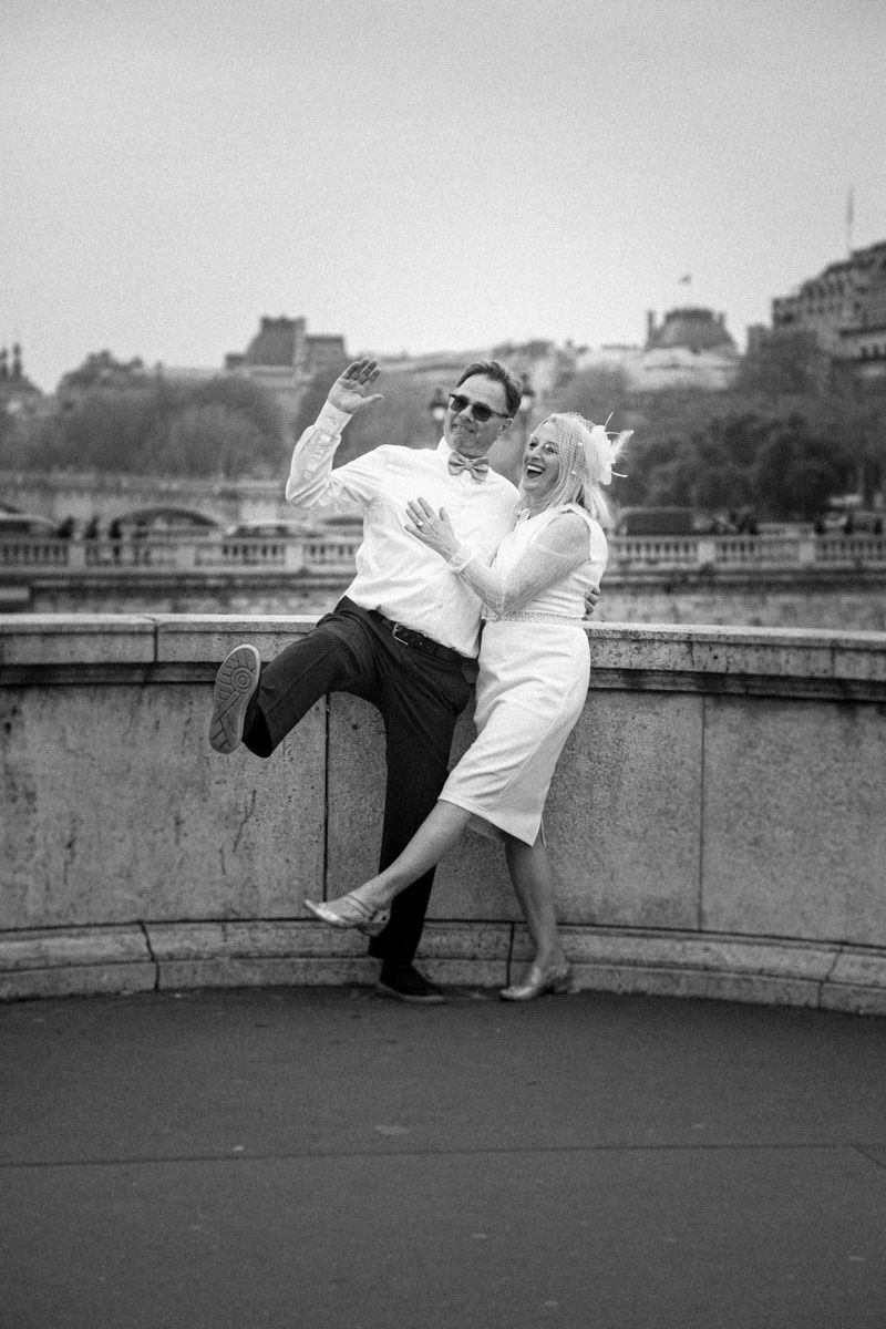 Playful black and white portrait on a stone terrace with Paris cityscape in background.