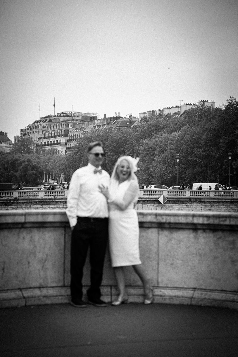 Elegant couple posing in Paris on a classic stone terrace.