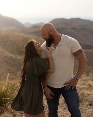 An intimate moment captured between a couple in the desert mountains during sunset.