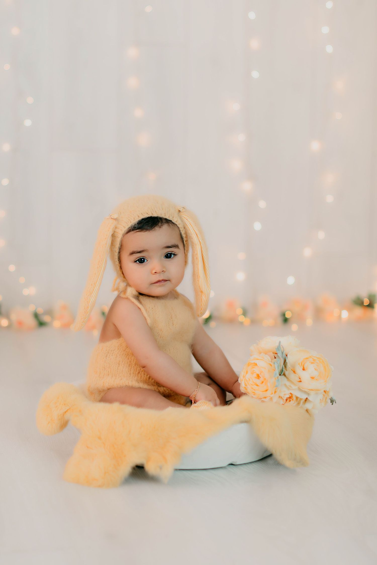 Niña de seis meses vestida de conejita en tonos amarillos en una sesión fotográfica de seguimiento.