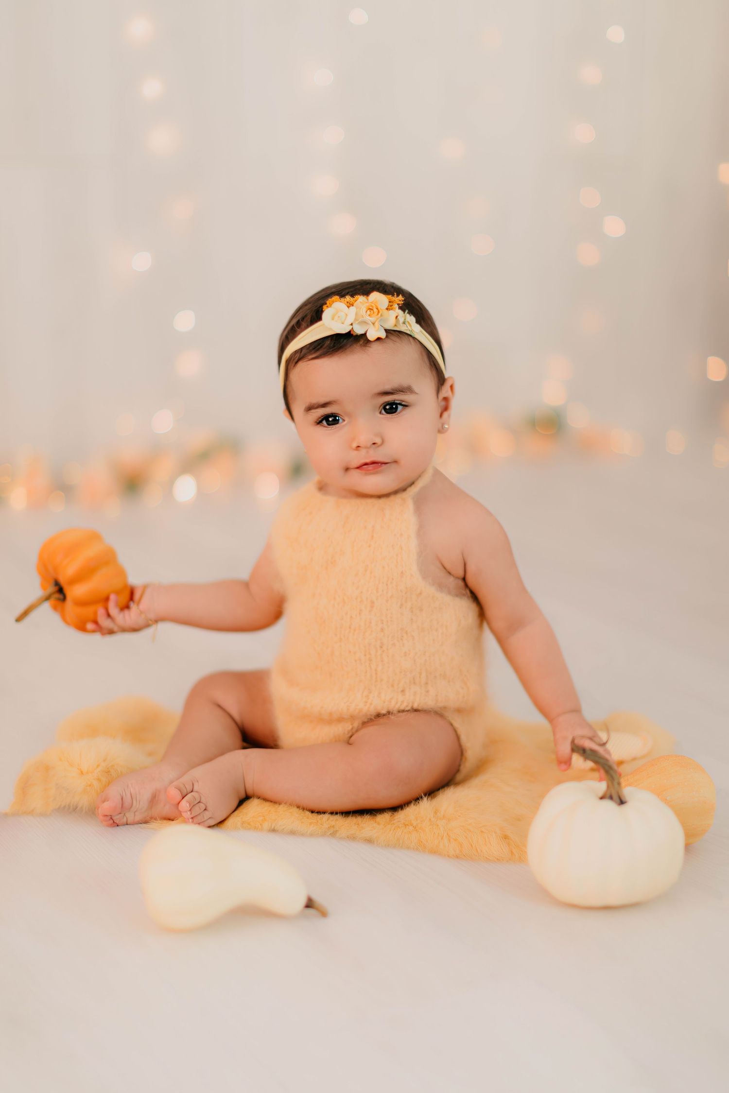 Niña de seis meses vestida en tonos amarillos en una sesión fotográfica de seguimiento.