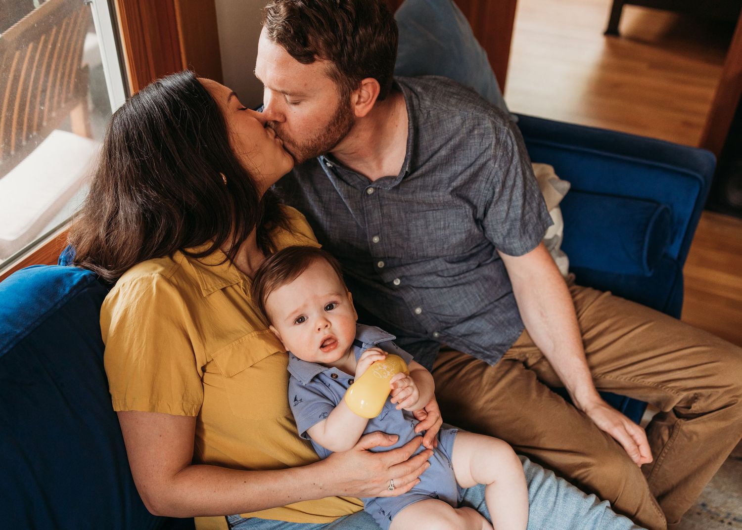 A cozy family scene on a blue sofa showing intimate moments of connection and love.