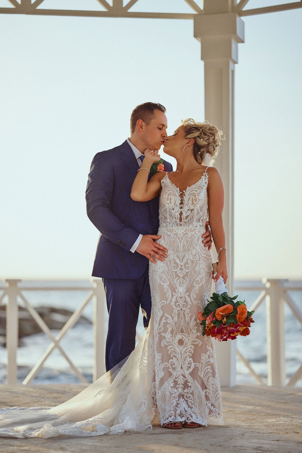 A romantic wedding couple sharing intimate moments in a beachside gazebo with elegant lace Jamaica Wedding Photographer