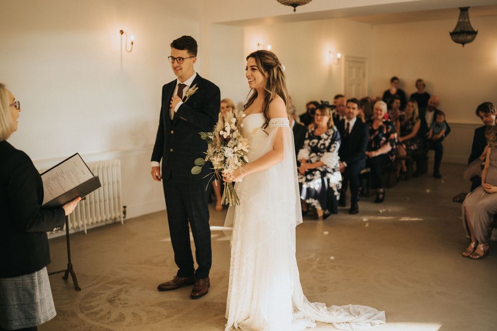Bride and groom stand together at wedding receeption venue with warm lighting at Aswarby Rectory.