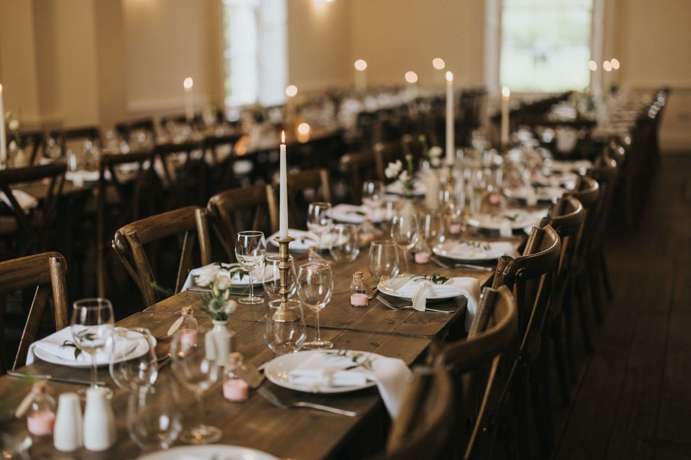 Long rustic dining table set with elegant place settings and glassware for an intimate wedding reception at Aswarby Rectory.