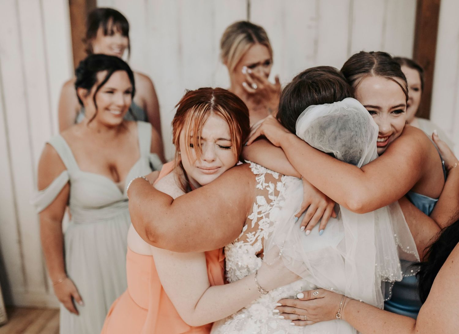Bride’s emotional first look with bridal party in pastel gowns