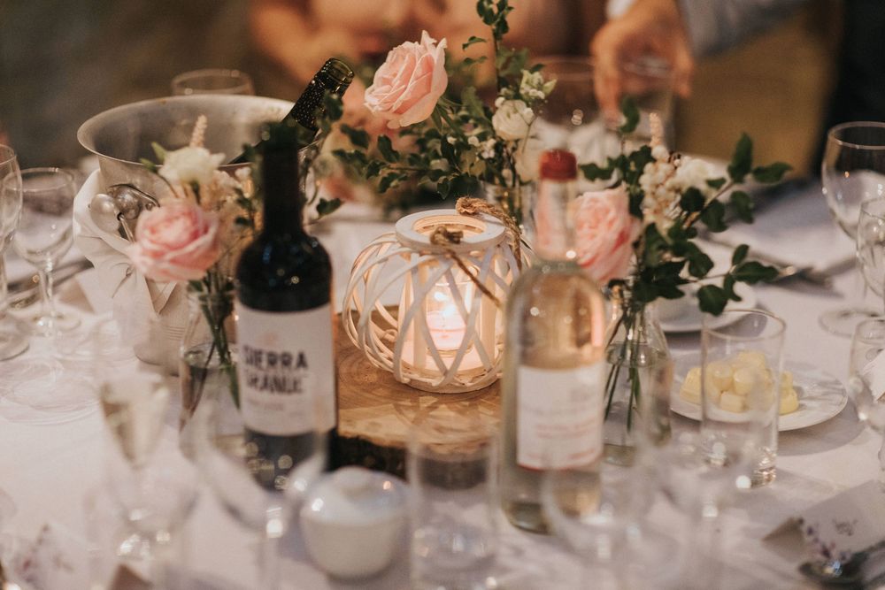 Elegant wedding reception tablescape with glowing candles, pink floral arrangements, and romantic table settings.