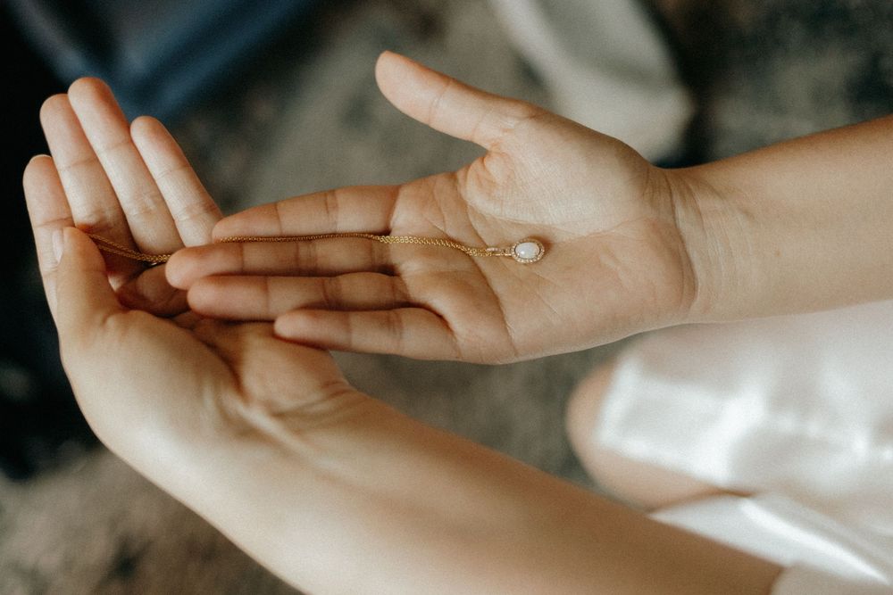 A white pill resting on an open palm against a dark background.
