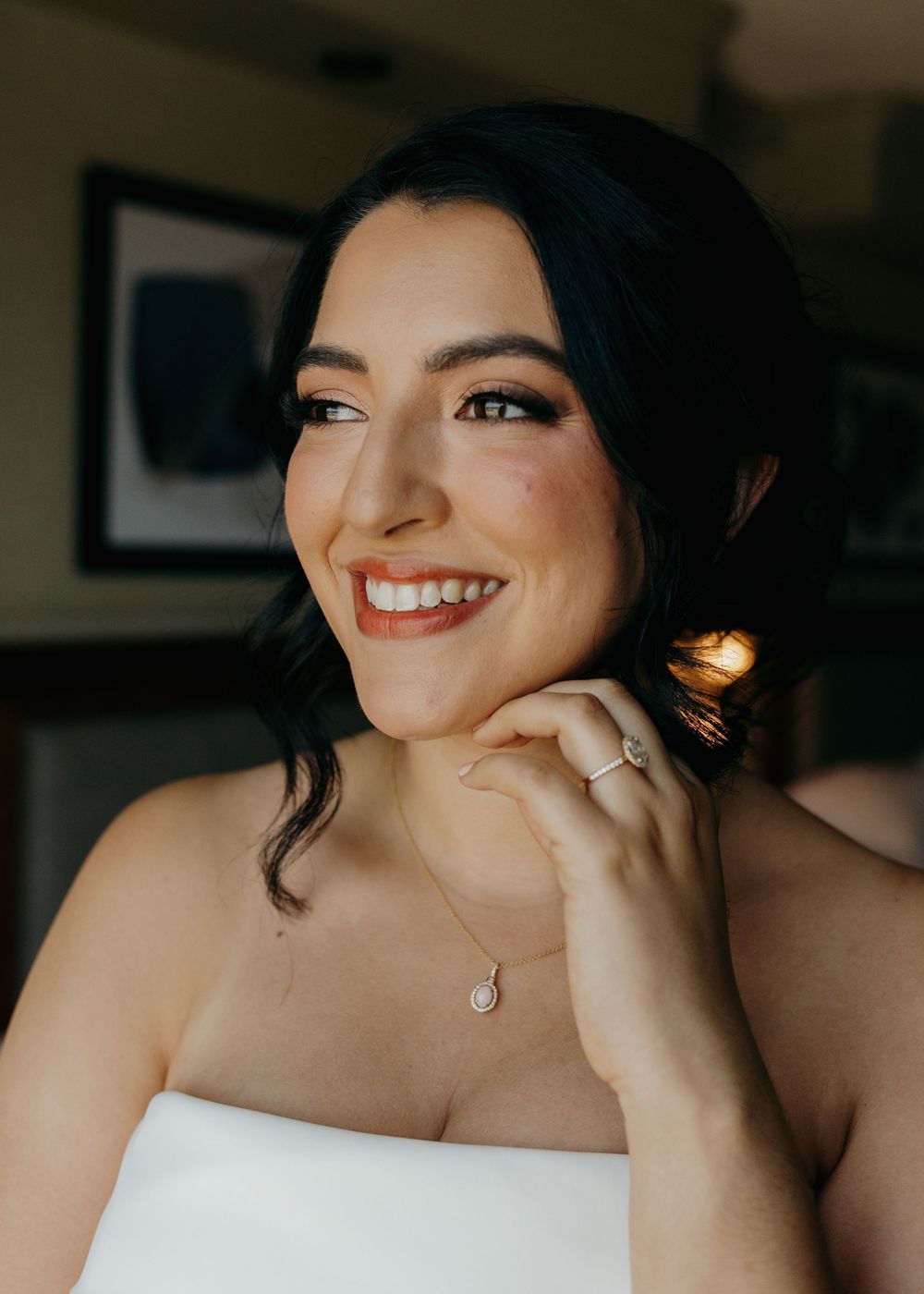 Woman in formal attire with dark hair and red lipstick smiles warmly in a sequence of candid portrait shots.