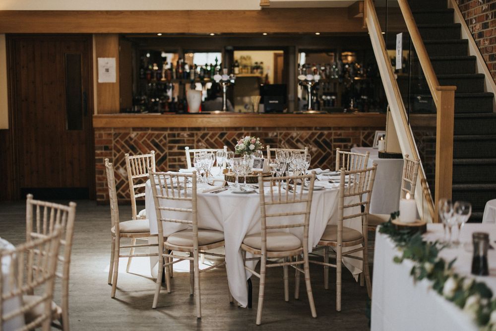 Elegant wedding reception setup with white Chiavari chairs and round tables at Hall Farm - image captured by Grimsby photographers.