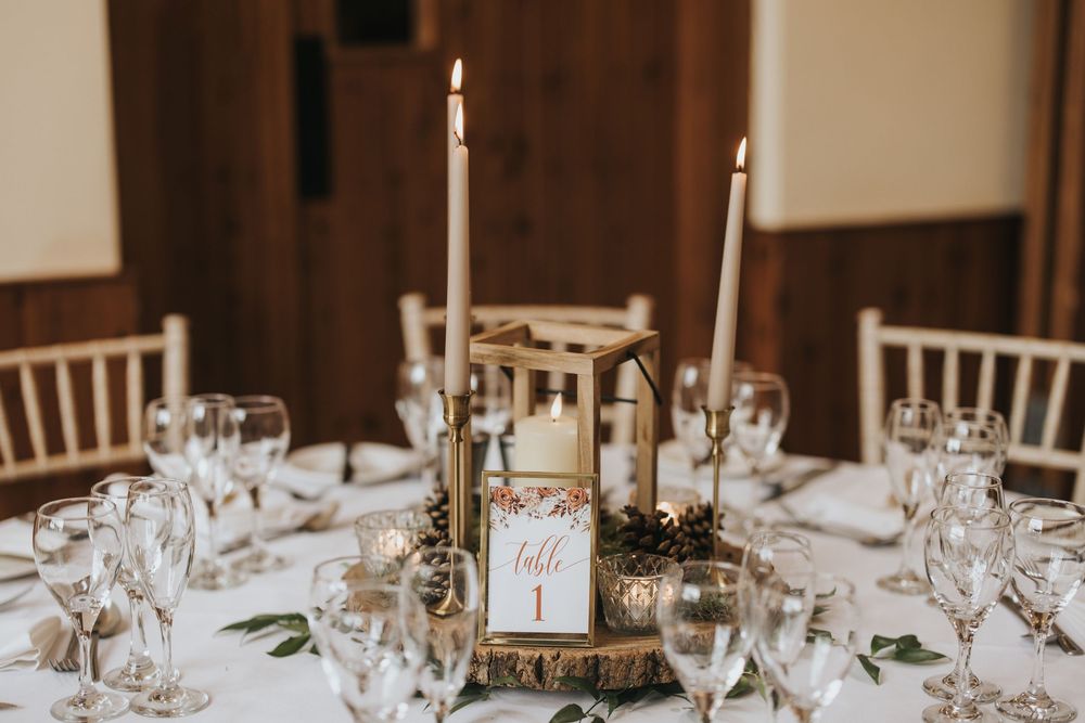 Elegant wedding table setting with tall white candles at Hall Farm - image captured by Grimsby photographers.