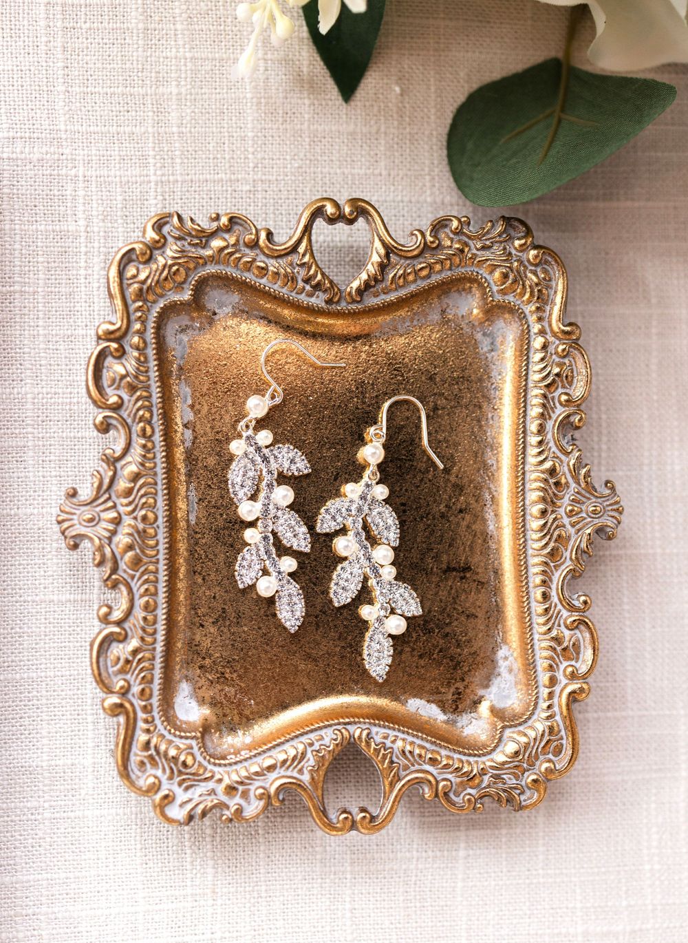 Ornate vintage gold frame plates displayed in sequence showing progression of decorative earring staging arrangement.