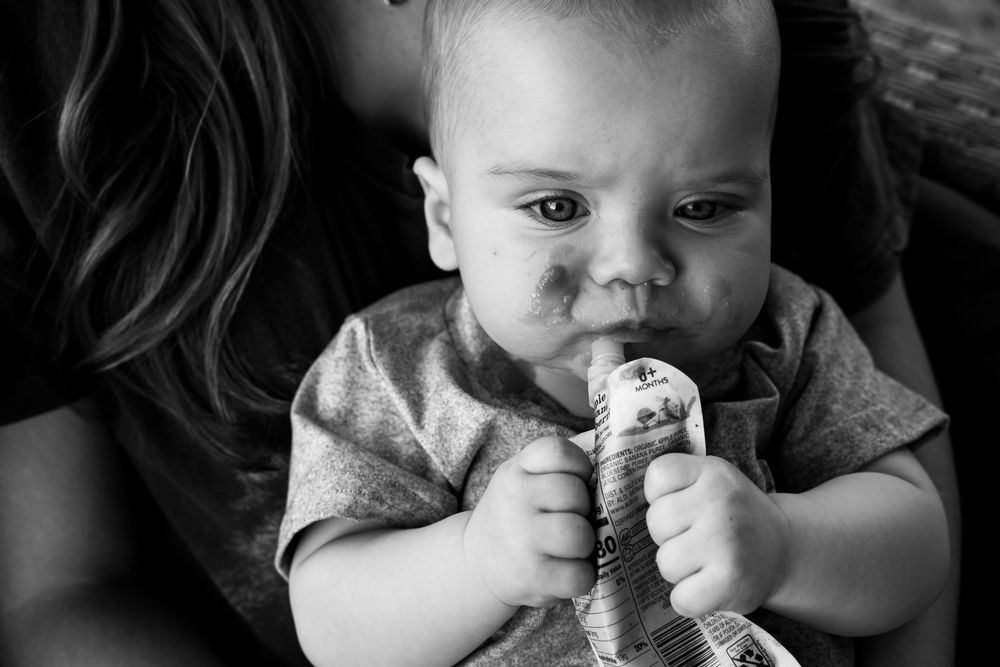 Baby with food all over face. Documentary family photography
