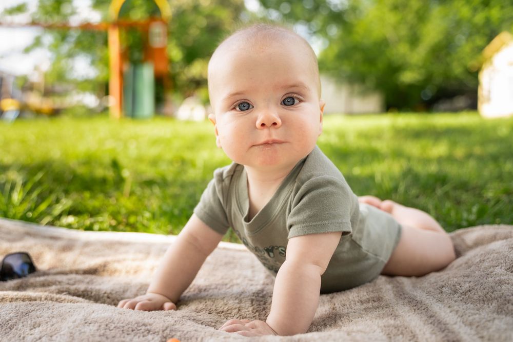 happy baby poses for camera during family photography session