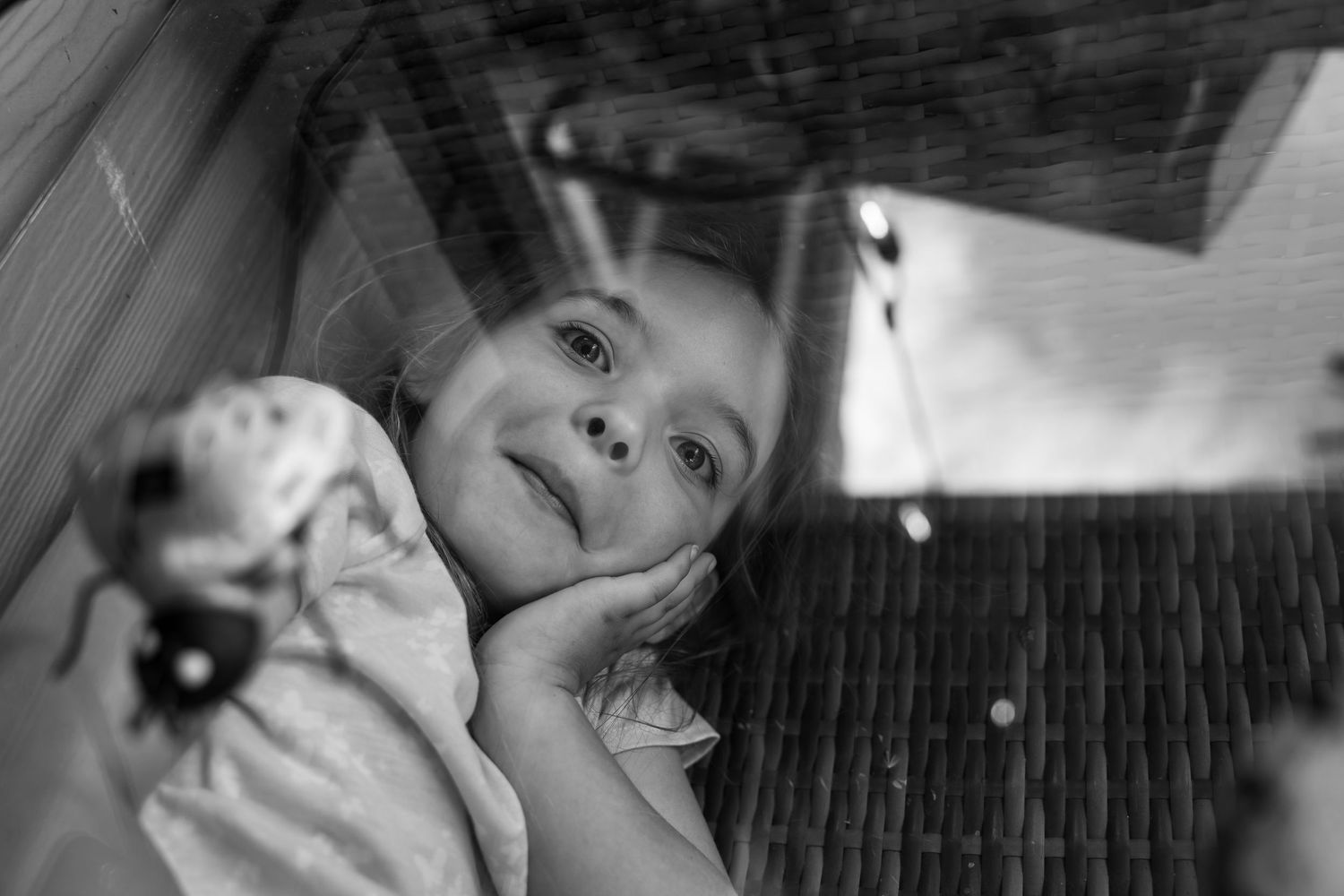 Girl Hides under glass table during hide and seek at an In Home Family Photography Session