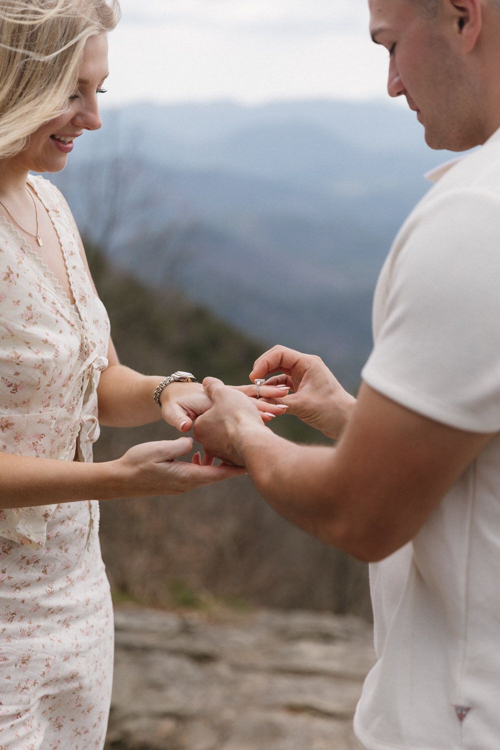 A couple shares an intimate moment exchanging rings on a blue ridge mountain overlook during a romantic elopement