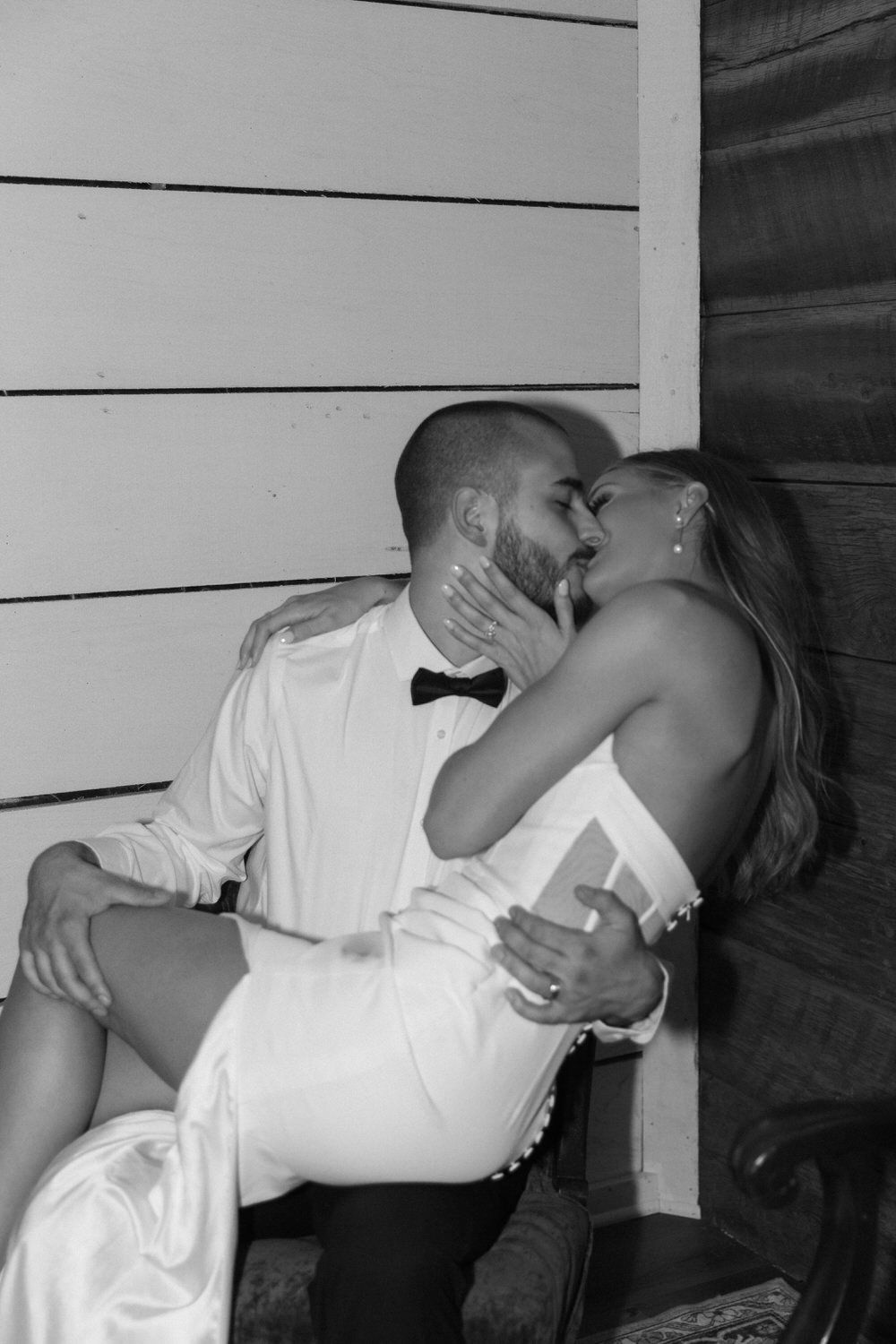 A romantic black and white elopement photo shows a couple sharing an intimate moment on their elopement night in colorado