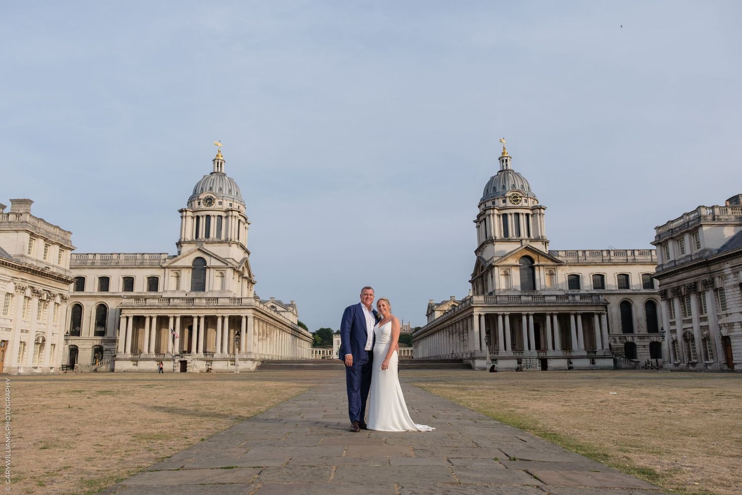 A couple poses for a wedding photo in front of the historic Royal Naval College in Greenwich, London.