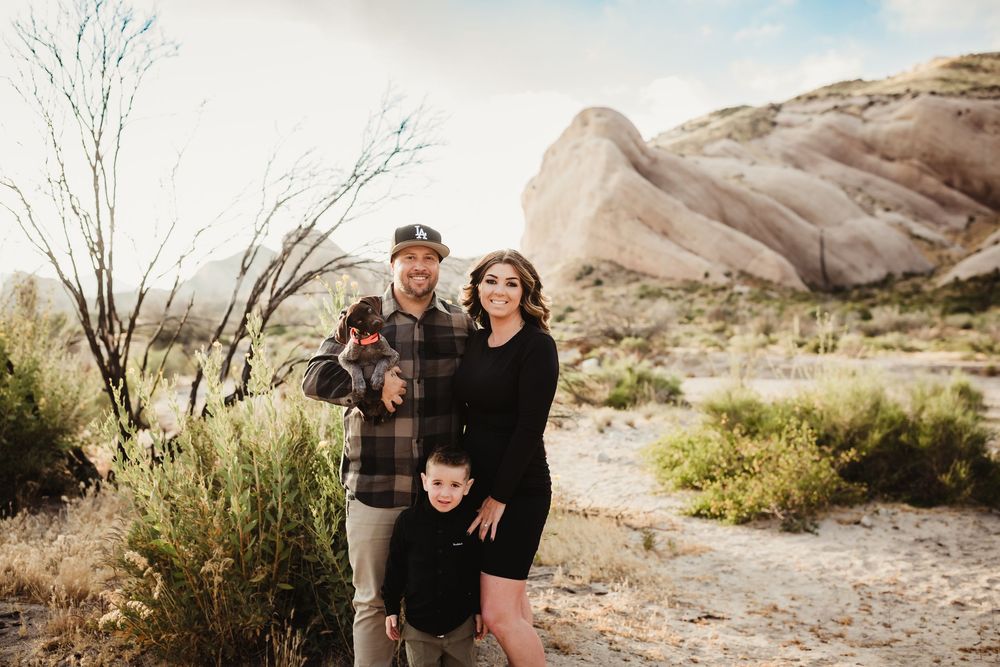 A couple enjoys a romantic desert engagement session amid rocky terrain at sunset.