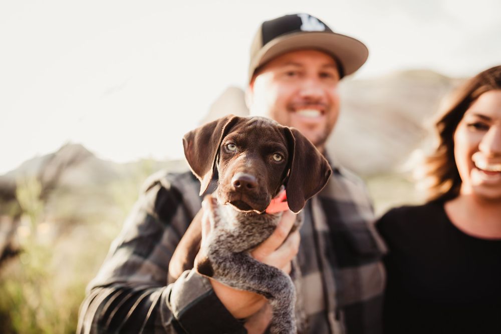 A family sits together enjoying playful moments outdoors in a desert landscape at sunset.