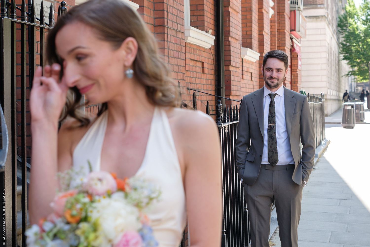 A sequence of candid wedding day photos showing a couple laughing joyfully outside a brick building with metal gates.