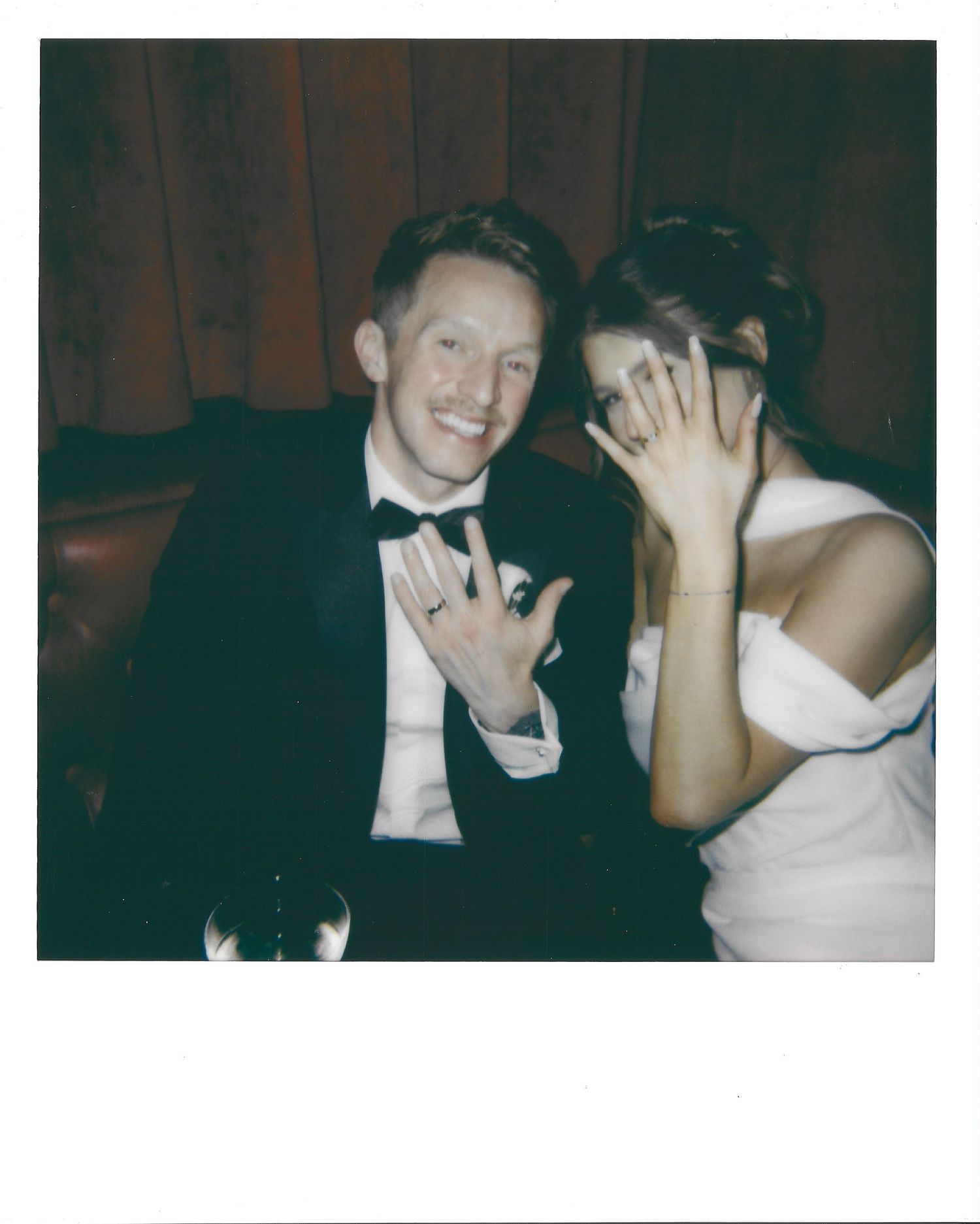 Wedding guests showing their hands with rings while smiling and celebrating at a joyful reception party.