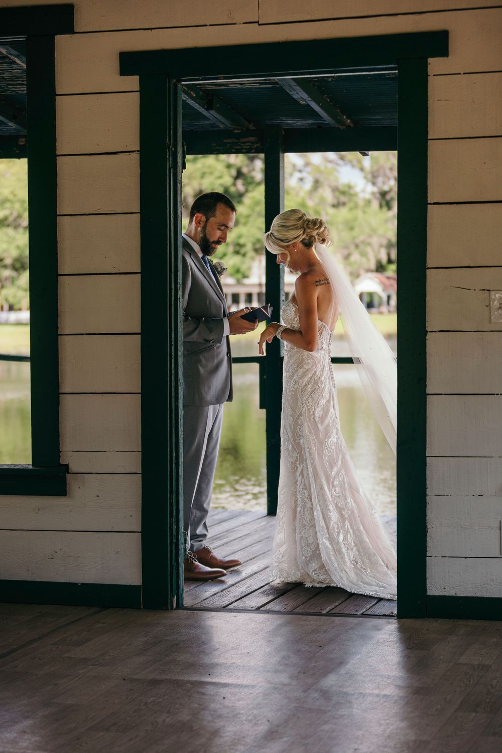 A first look wedding moment captured through doorways showing intimate emotions before the ceremony.