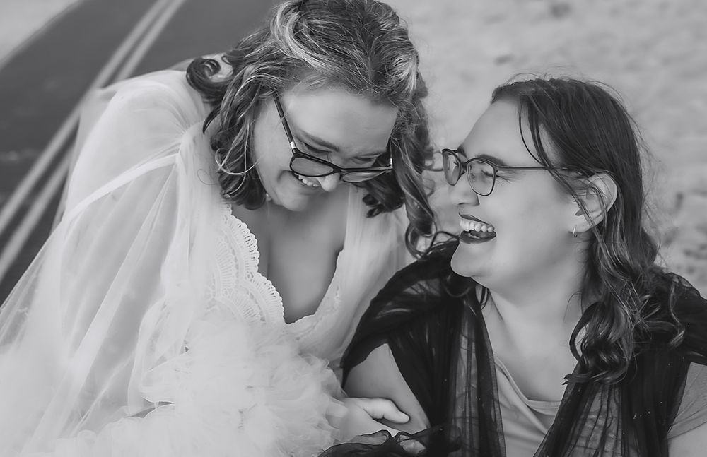 A touching black and white candid moment between two people laughing and sharing joy together on a special day.