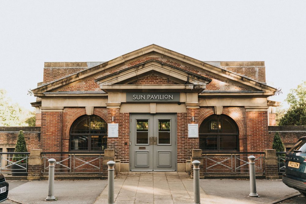 Historic train station building entrance with brick facade and classical architectural details at dusk.