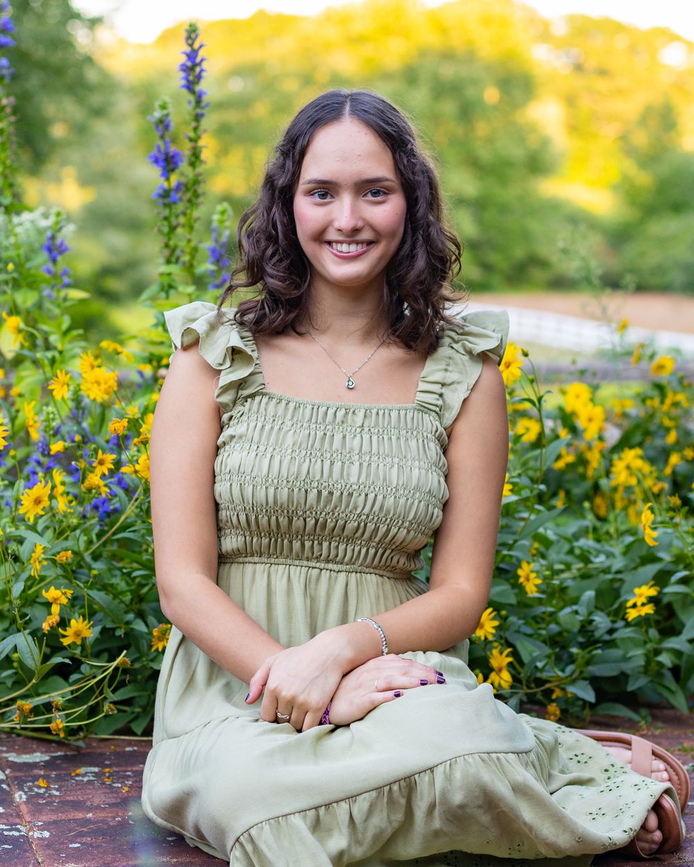 A peaceful outdoor portrait in a garden with vibrant purple lavender and yellow flowers on a sunny afternoon.