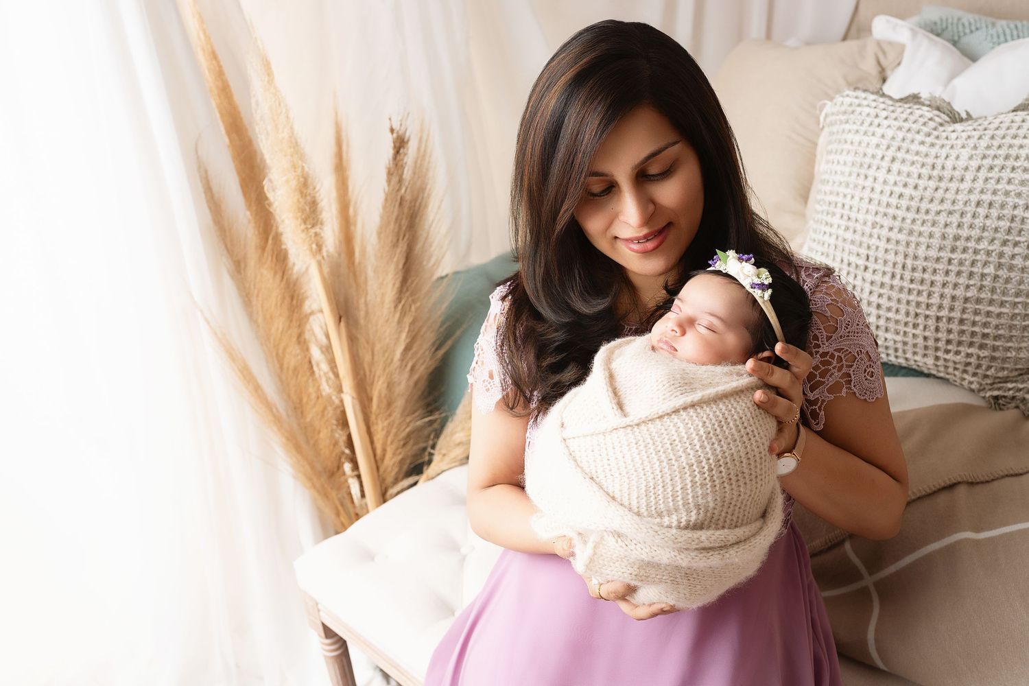 Tender family moment captured in soft neutral tones with pampas grass decor.