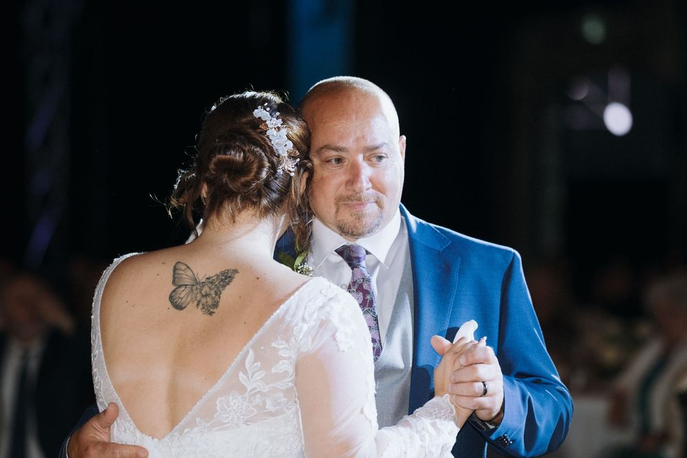 A tender father-daughter dance moment at an evening wedding reception.