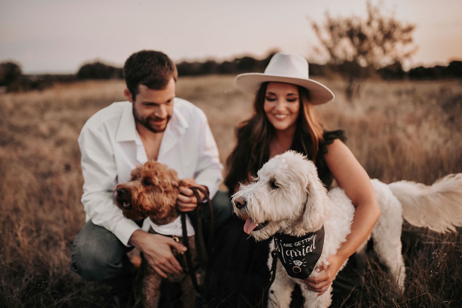 fur babies are cuddled by their mom and dad who are recently engaged and excited to take their engagement photos