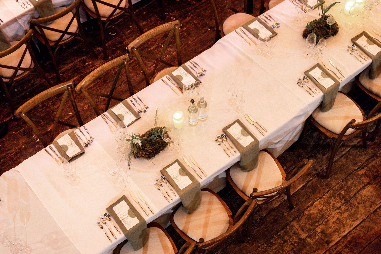 Elegant welcome sign in gold frame with pink floral arrangements and crystal vases on white table.