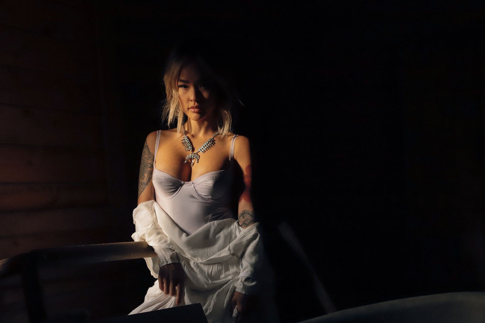 Atmospheric low-light portrait with dramatic shadows and soft lighting.