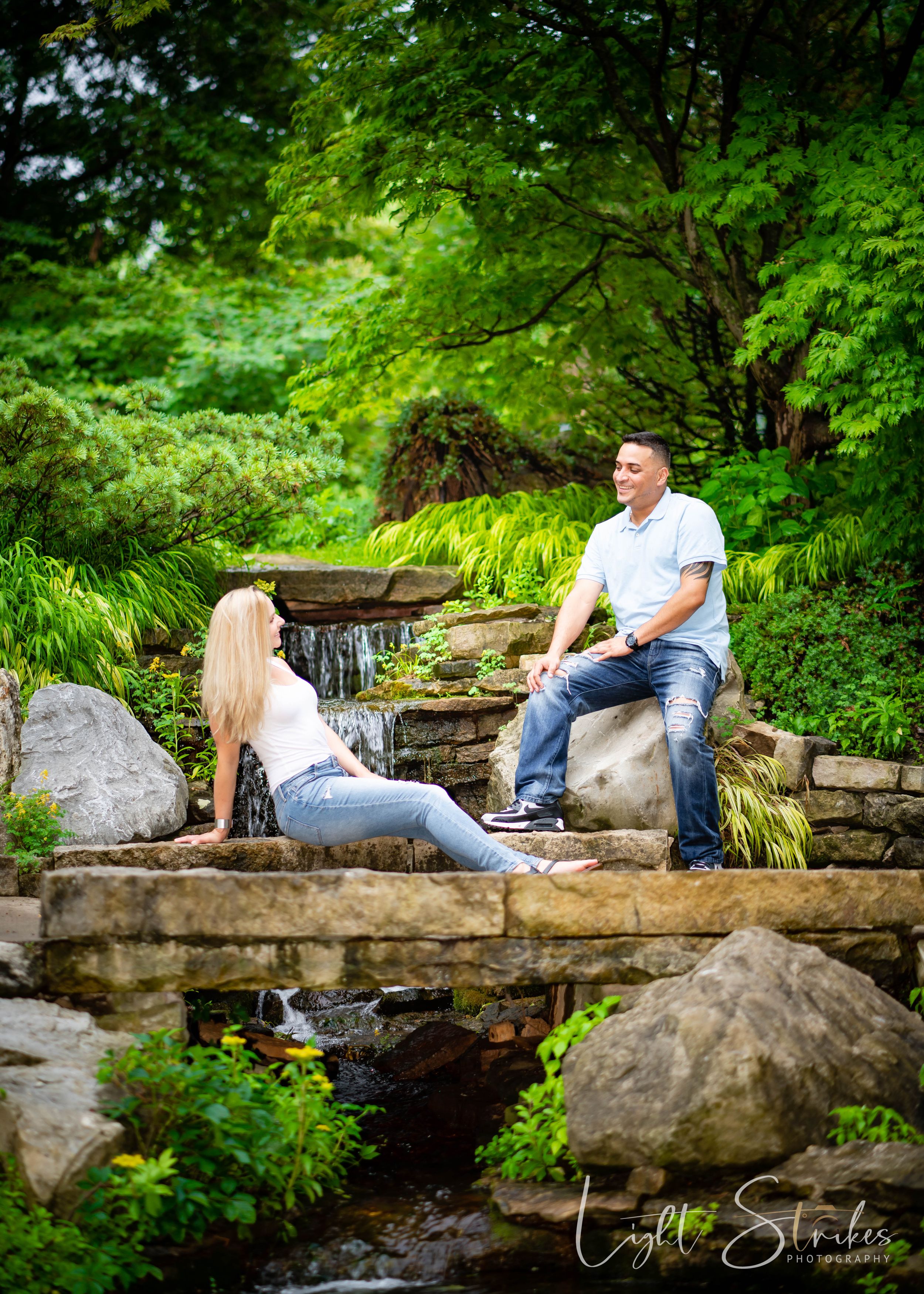 Engagement session of couple on a bridge with reflecting lighting captured by Charlotte wedding photographer