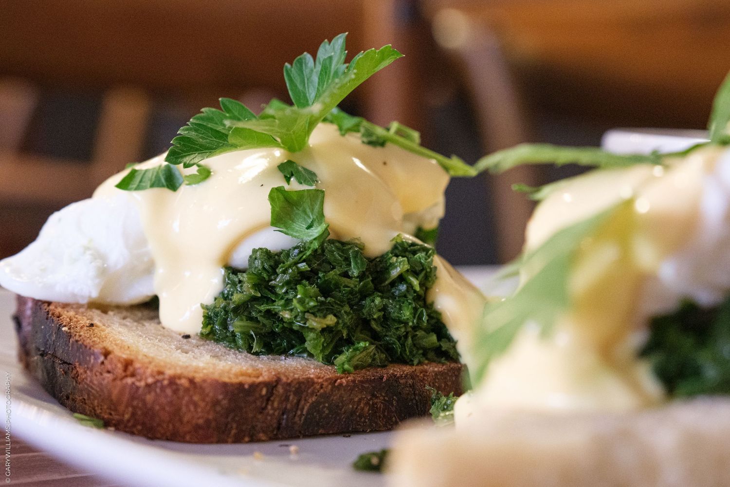 Eggs Benedict with fresh herbs and hollandaise sauce on toasted bread.