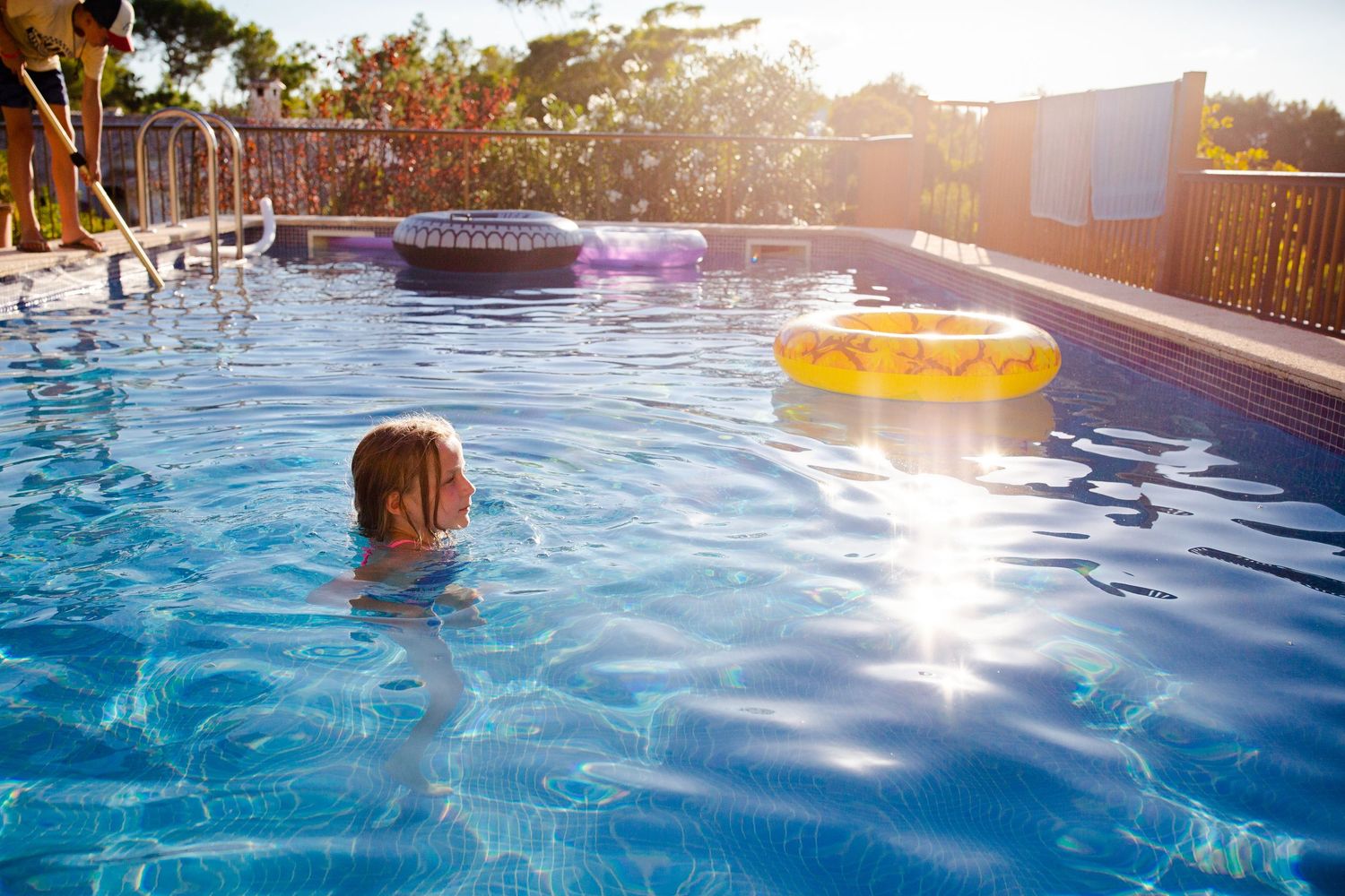 Girl in swimming pool with sun shining