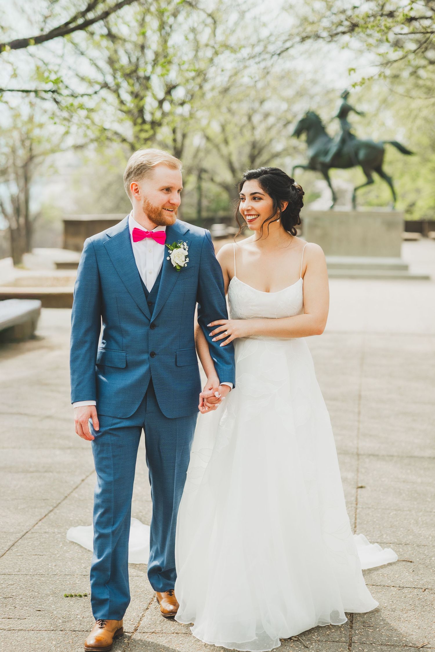 A wedding washington dc couple laughs while walking together on a paved path surrounded by spring trees at meridian hill park