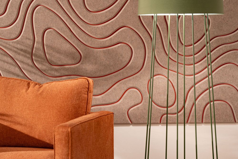 Mid-century modern interior setting with orange armchair against textured wavy wall pattern and gold floor lamp.