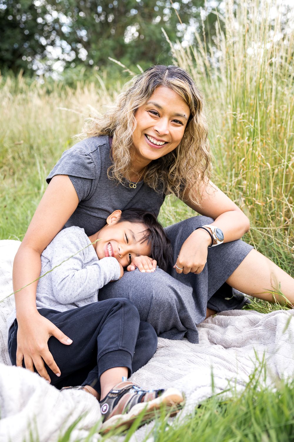mum and son sitting on the grass in the park