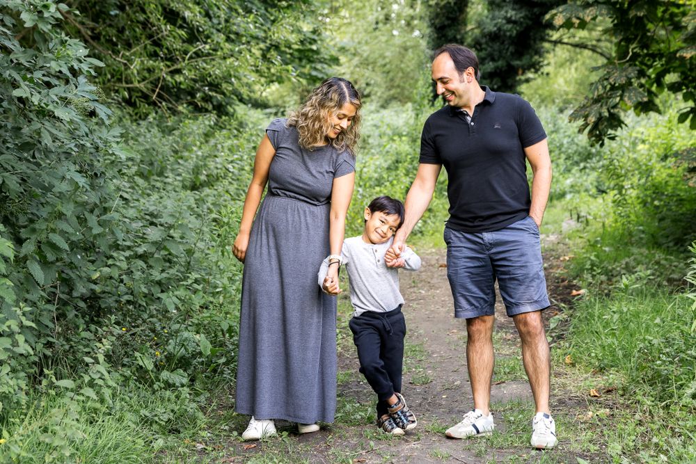 mum and dad holding hands with their son