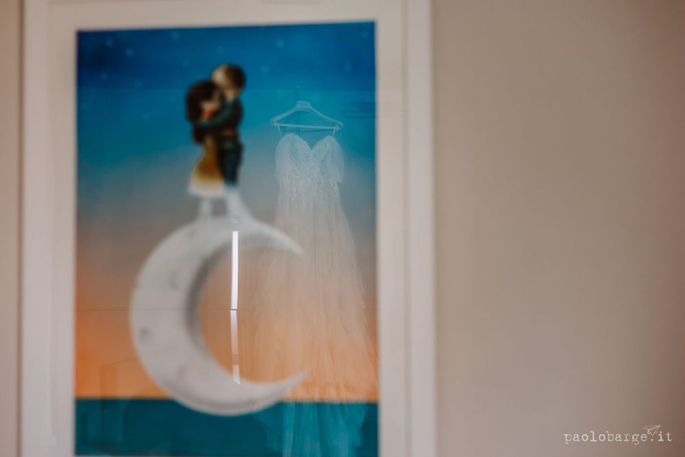 Decorative white crescent moon ornament against a blue and orange gradient background.