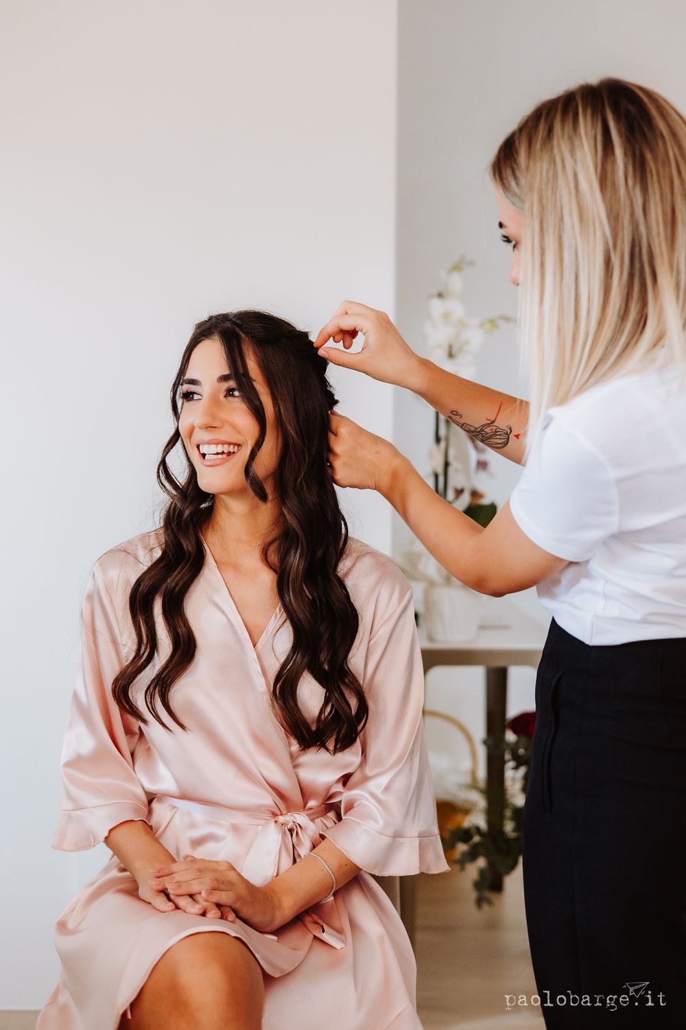Hair styling session with person in pink silk robe getting ready.