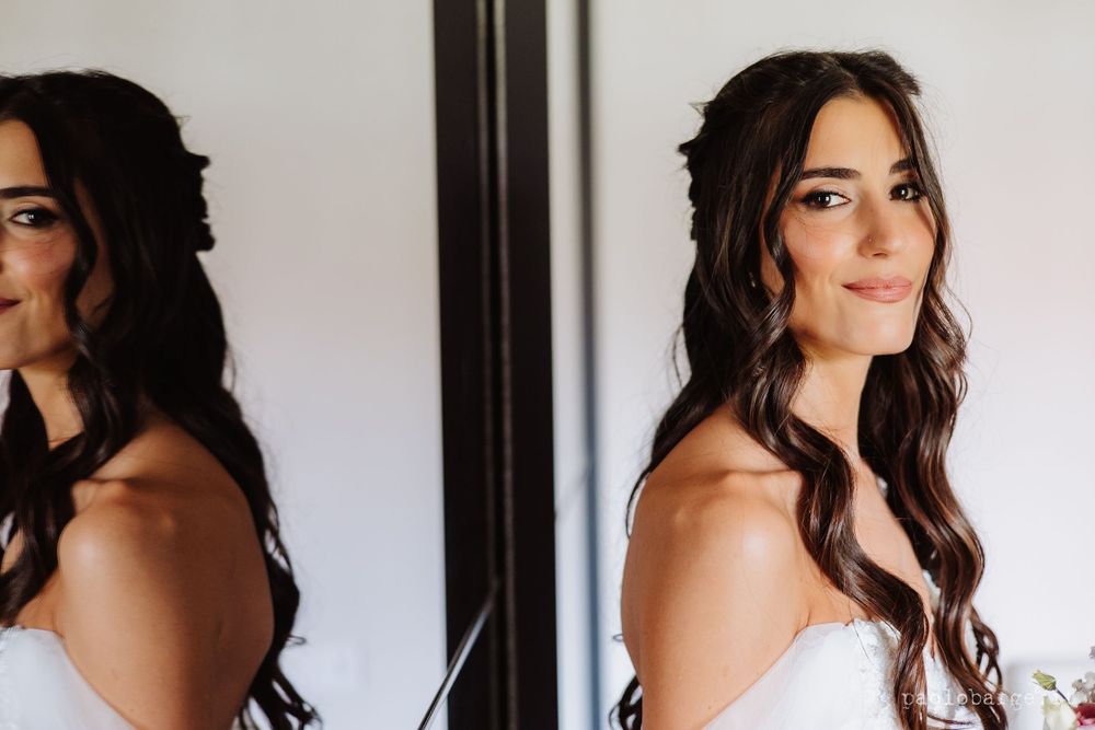 Mirror reflection captures bridal beauty preparation moment.
