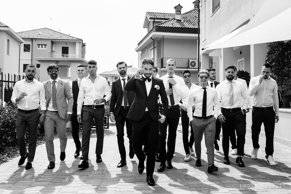 Black and white photo of groomsmen walking together in formal attire.