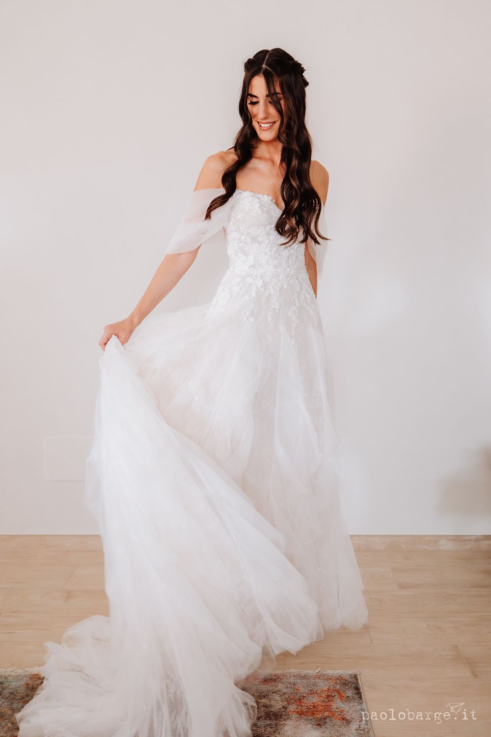 Full-length portrait of bride twirling in flowing white wedding gown.